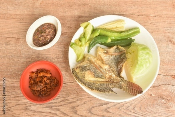 Fototapeta batter fried tilapia fish with boiled vegetable on plate dipping spicy shrimp paste sauce