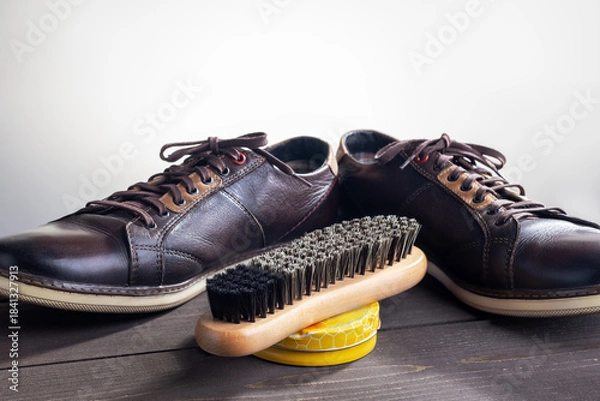 Obraz Shoe care products and footwear on dark wooden table.