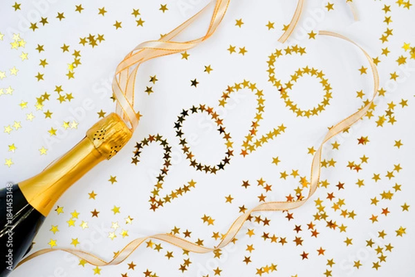 Obraz Champagne bottle stands ready to pop as golden ribbons and starry confetti spell out the year 2026 in a festive atmosphere. Perfect for welcoming the New Year with cheer