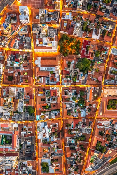 Fototapeta Illuminated urban grid of Getsemani Cartagena Colombia. Colorful rooftops and evening streets. Dron.
