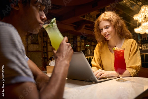 Obraz Man and woman toasting with colorful drinks