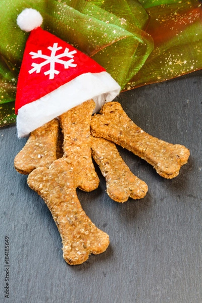 Obraz Weihnachtsmütze mit Hundekeksen gefüllt