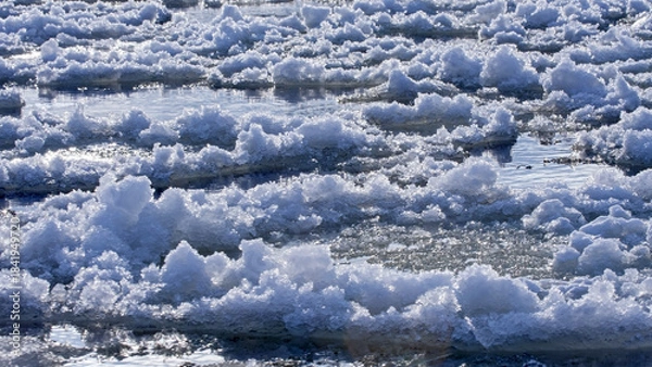 Obraz Ice floes float on a frozen river on a sunny winter day. Ice has formed on the Neris River in eastern Lithuania.