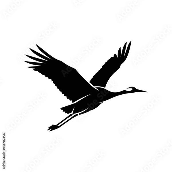 Fototapeta Black silhouette of a crane bird in graceful flight with wings spread wide against a plain background.