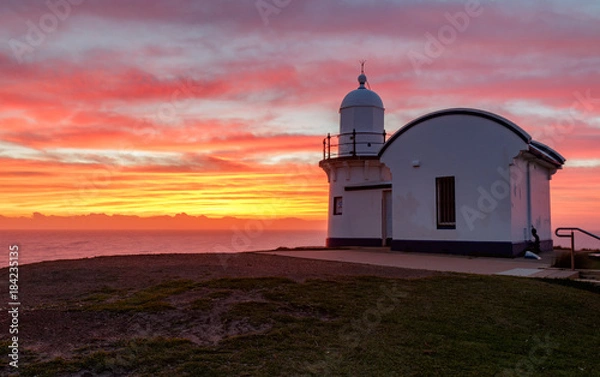 Fototapeta Tacking point lighthouse at dawn, yellow and red
