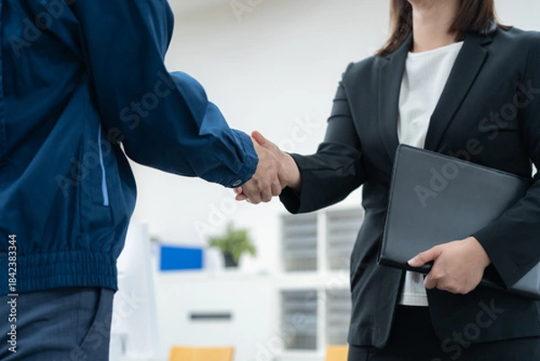 Obraz オフィスで握手をする作業服のエンジニア