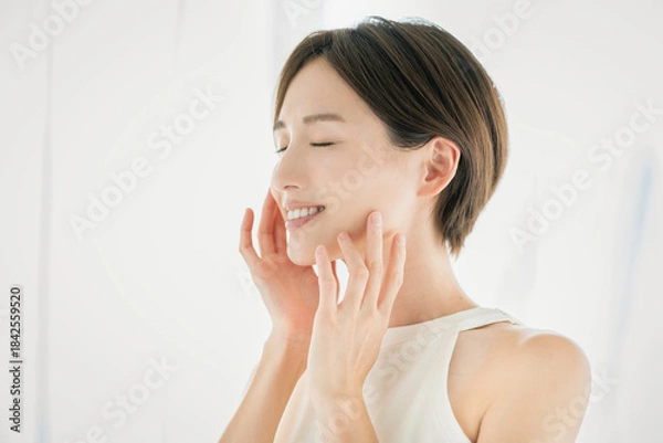 Obraz 顔を触っている笑顔の若い女性