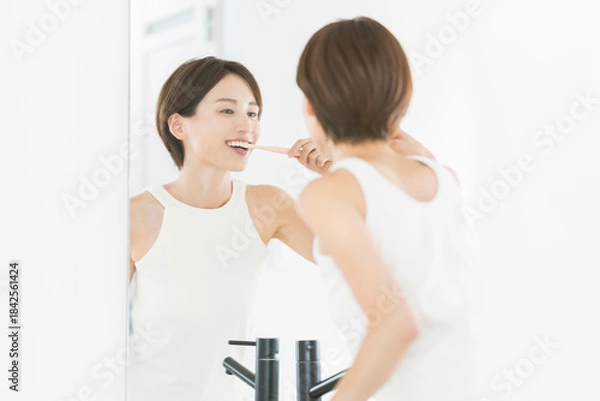 Fototapeta 鏡を見ながら歯を磨いている女性