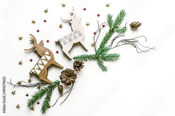 Fototapeta Christmas composition with deer, stars and fir branches. New Year background for presentation of work or text. Beautiful greeting card. Copy space.Top view