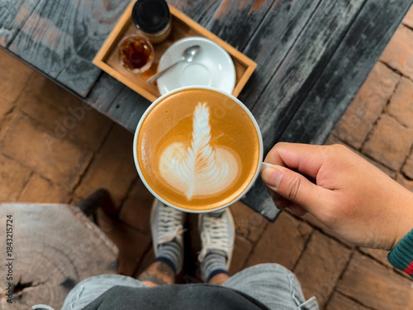 Fototapeta Hot coffee. Holding a hot latte in a mug from the cafe.