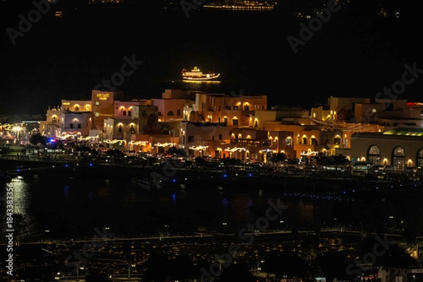 Fototapeta Doha, Qatar - December 10, 2025: Night view of Old Doha port redevelopment into Mina district Box Park Qatar