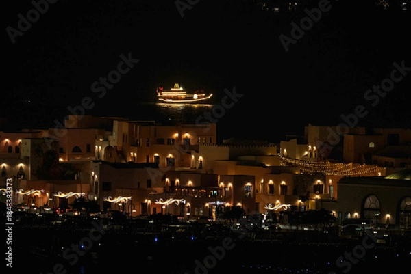 Fototapeta Doha, Qatar - December 10, 2025: Night view of Old Doha port redevelopment into Mina district Box Park Qatar