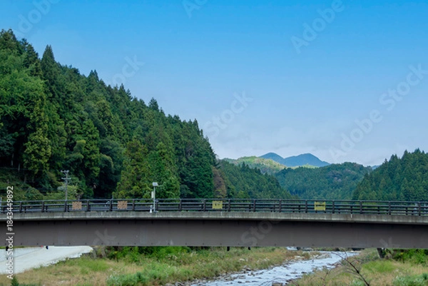 Obraz 山間部を流れる川に架かる橋のある風景
