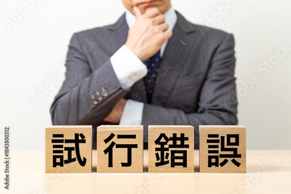 Fototapeta 「試行錯誤」と書かれたブロックとビジネスマン