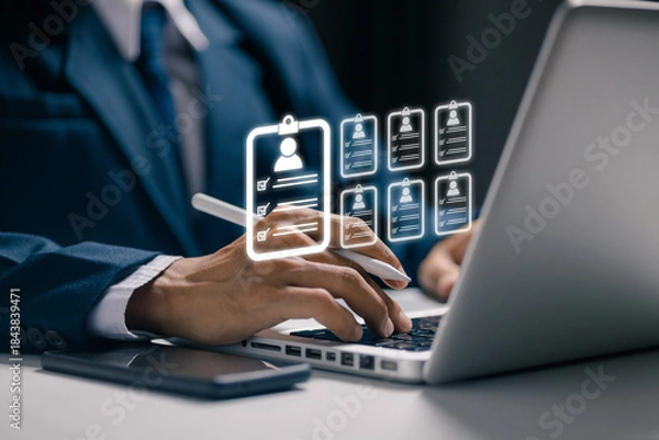 Fototapeta A recruiter reviews multiple digital resumes on a laptop, representing candidate databases, talent screening, recruitment technology, employee evaluation, and modern hiring systems.