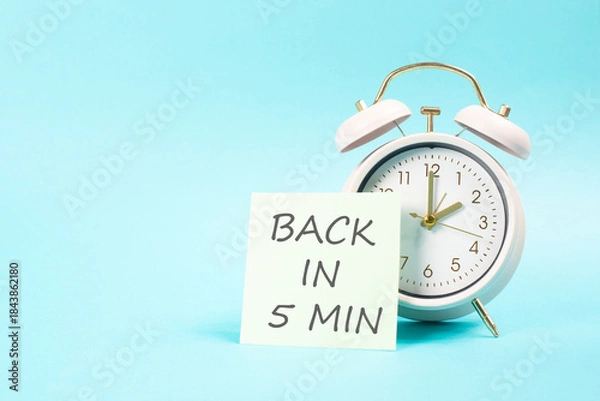 Fototapeta Back in 5 min, note on paper, message, working break, be right back, office desk, alarm clock
