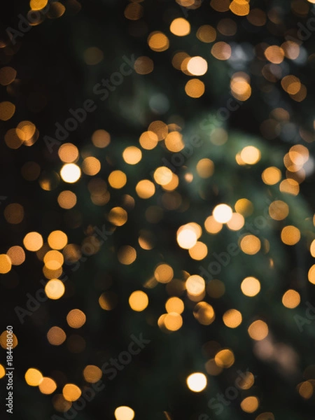 Fototapeta Blurry, golden Christmas fairy lights on outdoor christmas tree at the castle of Nuremberg in the snow during winter creating a beautiful bokeh effekt
