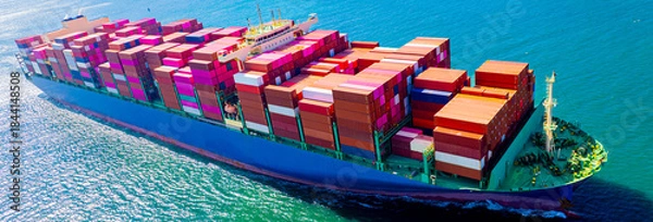 Fototapeta container ship, fully loaded with goods, sails out to sea, delivering products to various locations