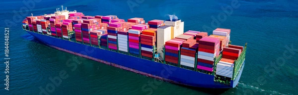 Fototapeta container ship, fully loaded with goods, sails out to sea, delivering products to various locations