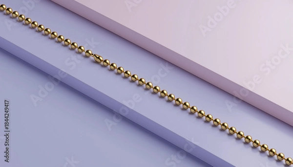 Obraz A long golden beaded chain lying diagonally across a minimalist background with light purple and pink sections.