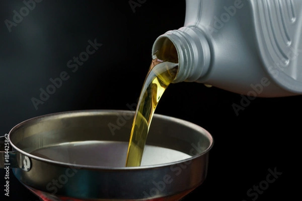 Obraz Engine oil pouring on black background. 
