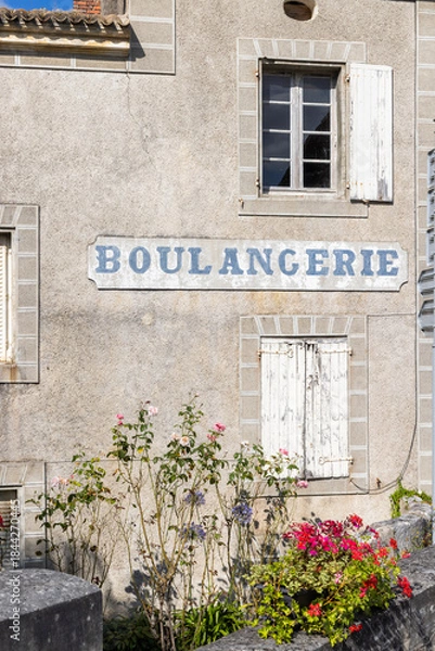 Fototapeta Traditional boulangerie shopfront with blooming flowers in Combiers France