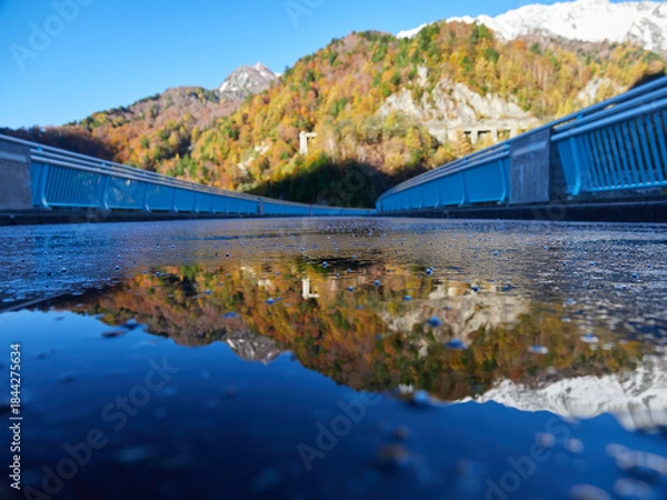 Obraz 秋の観光名所立山黒部アルペンルートの黒部ダムの貯め水に映すカラフルな紅葉と初雪の雪山の風景