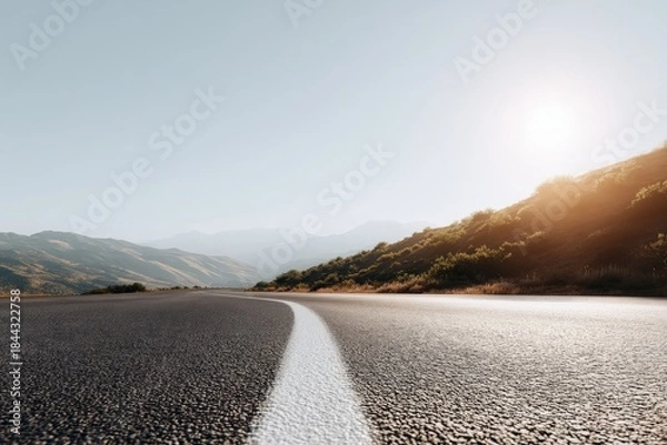 Fototapeta Low-angle close-up of a textured asphalt road with white dividing line in sharp focus