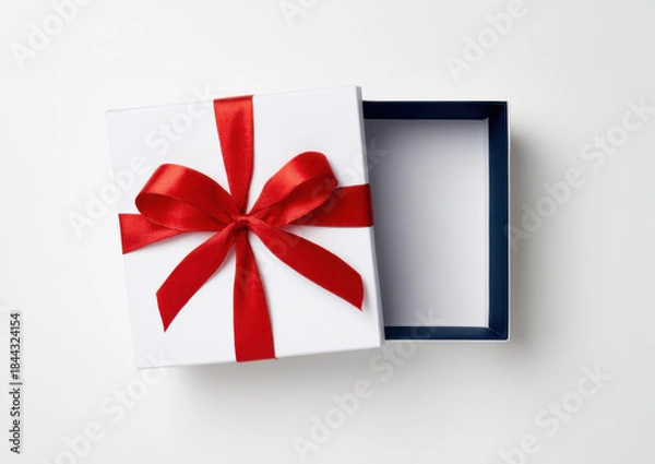 Fototapeta A gift box with a ribbon sits open on a light surface