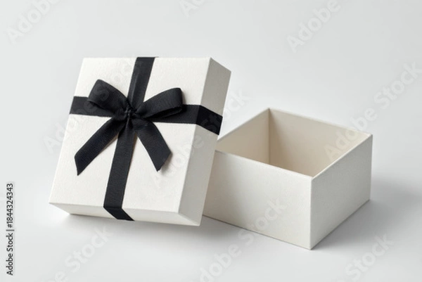 Fototapeta A gift box with a ribbon sits open on a light surface