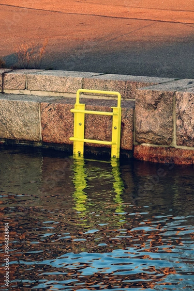Obraz Yellow ladder leading into water at the seafront.