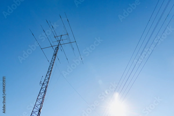 Obraz 青空を背景にした送電線と通信アンテナ（無線塔）