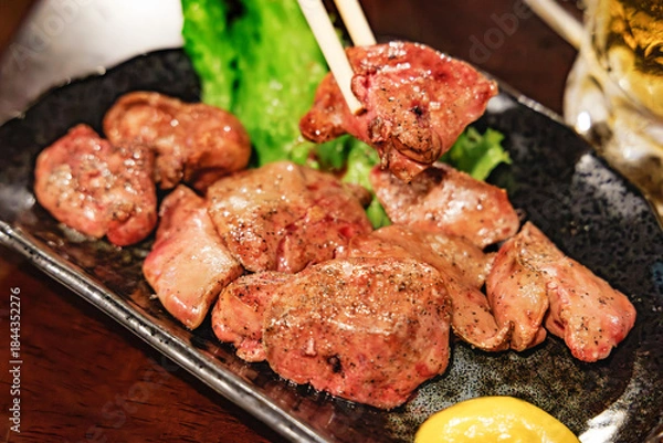 Obraz 箸で持ち上げられた照り焼き風の濃厚な鶏レバー（レバー焼き