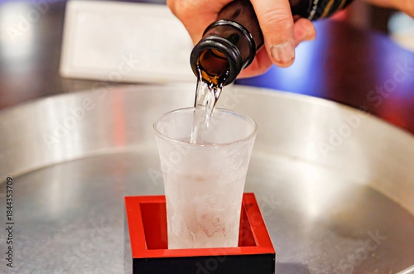 Obraz 日本酒を升の中の冷えたガラスのコップに注ぐ手元のクローズアップ