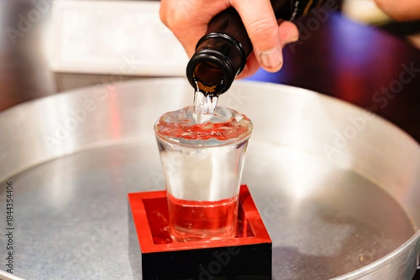 Obraz 日本酒を升の中の冷えたガラスのコップに注ぐ手元のクローズアップ