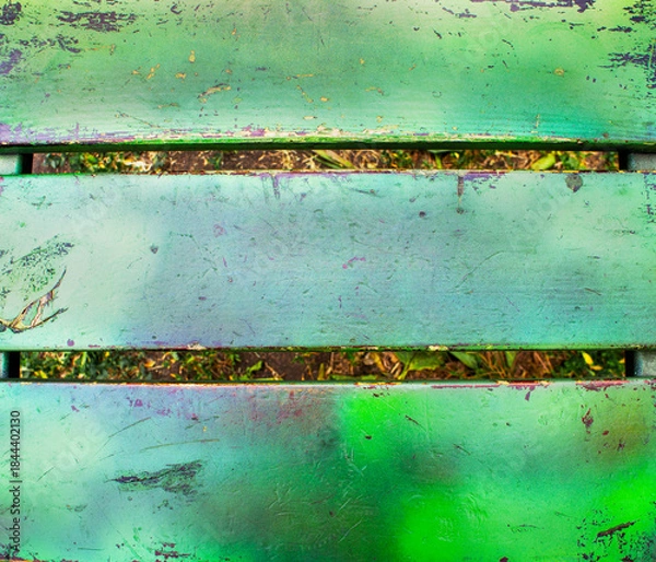Fototapeta Close-up of a weathered green wooden bench with peeling paint and visible scratches, rustic outdoor texture abstract background with copy space