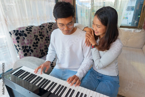 Fototapeta The couple is practicing playing a musical instrument.