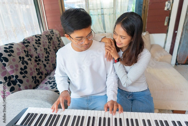 Fototapeta The couple is practicing playing a musical instrument.