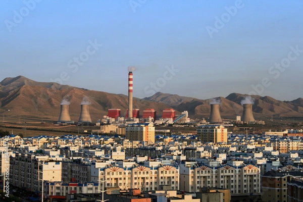 Obraz The Chinese city of Urumqi. Urban quarters and a huge thermal station in the background of the Tien-Shan mountains.