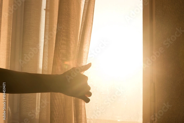 Obraz Female arm reaching out to open a curtain - warm sun light shining through
