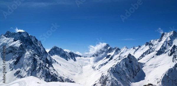 Fototapeta Panoramic view of snow covered mountain peaks