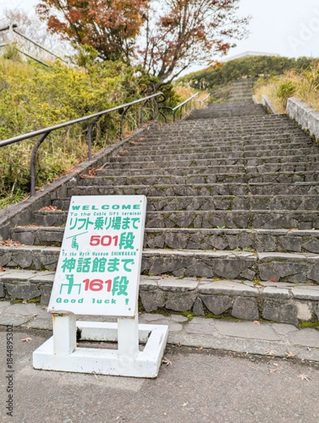 Obraz 長い石段と案内板が続く山道の風景