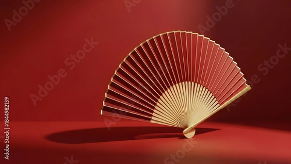 Fototapeta Elegant wooden hand fan displayed against red background  