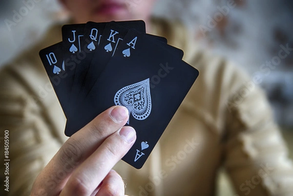 Fototapeta Royal Flush (oldest Straight flush) of spades poker cards combination in hand of man (croupier or card cheater). Big size HDR.