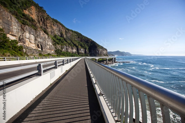 Fototapeta View of the famous Sea Cliff Bridge located on the Illawarra coastline north of Wollongong, NSW Australia. Captured from the scenic walkway looking north to Stanwell Park on a bright blue sunny day.