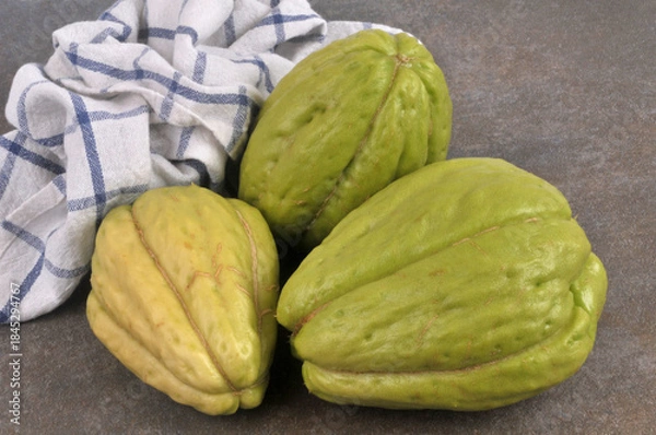 Obraz Chayotes entières et crues en gros plan isolées sur fond gris avec un torchon