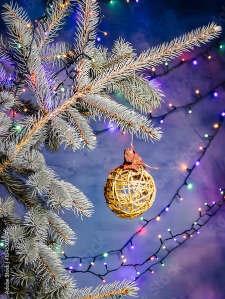 Obraz Frosted Pine Branch With Gold Woven Ornament And Colorful Christmas Lights