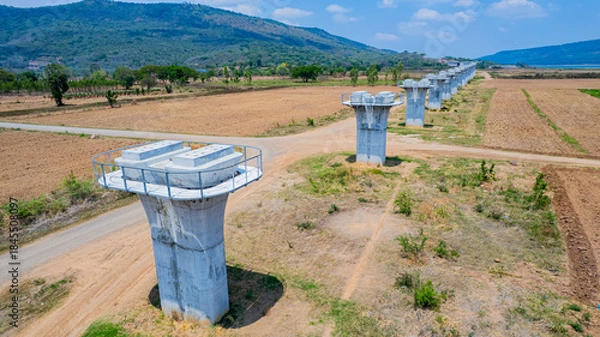 Fototapeta The concrete pillars/piers for the high-speed rail track are under construction at the unfinished construction site.