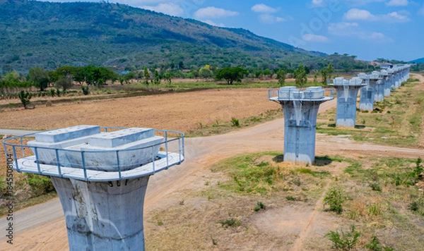 Fototapeta The concrete pillars/piers for the high-speed rail track are under construction at the unfinished construction site.