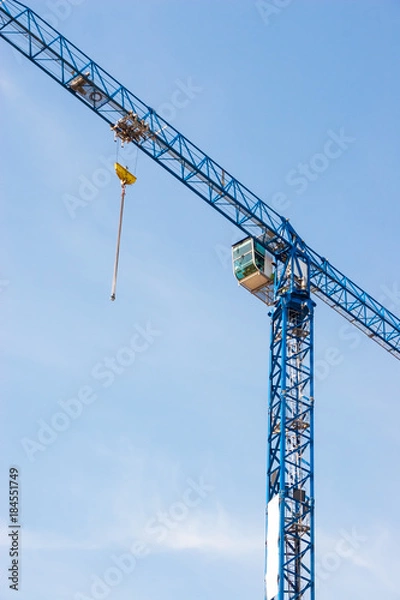 Obraz Industrial construction crane hoisting against blue sky